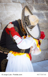 Pareja de novios con traje tradicional mexicano. Pareja besndose. Pareja tapados con sombrero demostrndose amor.