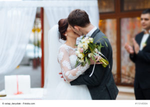 Ein Brautpaar küsst sich liebevoll und innig nach der Hochzeit - Bild: ostap_davydiak - fotolia.com