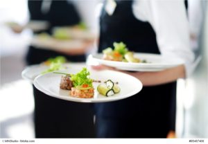 Waiter carrying plates with meat dish © MNStudio